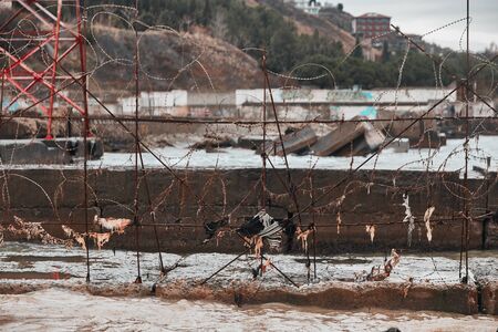 closed muddy shore fenced with barbed wire and breakwatersの写真素材