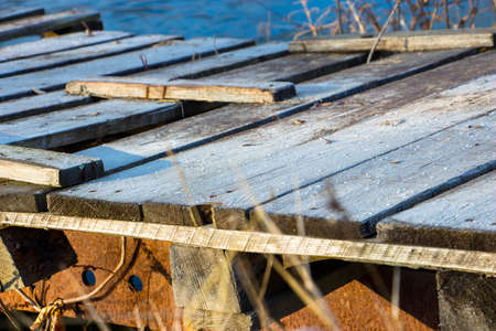 Wood old bridge covered with frost over the small river in fallの写真素材