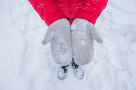 Ivory woman gloves in snow with red coatの写真素材