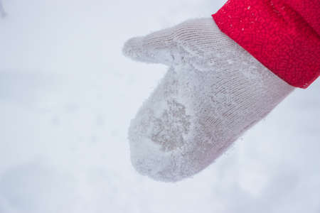 Ivory woman glove in snow with red coatの写真素材
