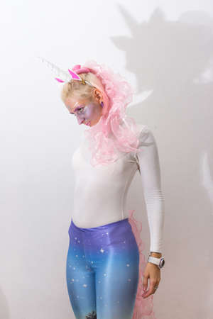 Pink cute sexy girl unicorn on white background. young woman close up portrait. Halloween costumeの写真素材