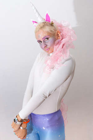 Pink cute sexy girl unicorn on white background. young woman close up portrait. Halloween costumeの写真素材