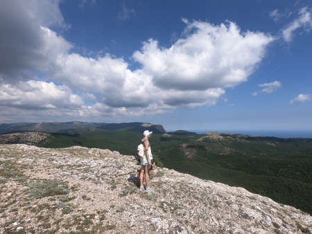 Sport girl standing on the cliff of the mountain looking at sea, aerial viewの写真素材