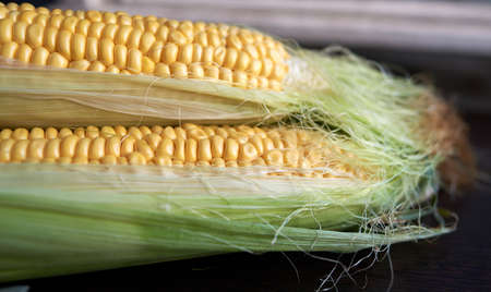 Four golden ears of corn with leaves. Low key. Top viewの写真素材