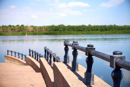 Close-up of an iron stepped fence against a blurred background of the Volga riverの写真素材