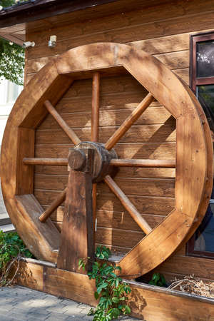 Decorative sunlit wooden mill wheel in a city street