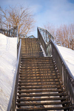 Rusty old staircase to the sky among the snowの写真素材