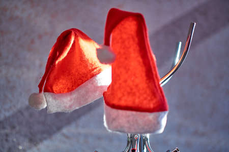 Two Santa Claus hats hang on a hangerの写真素材