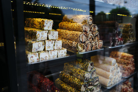 Turkish delight of various types - chocolate, fruit, with pistachios - is stacked on a shop window in Istanbulの写真素材