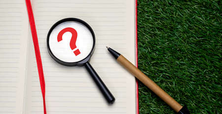 Magnifying glass on white sheet of Notepad, top viewの写真素材