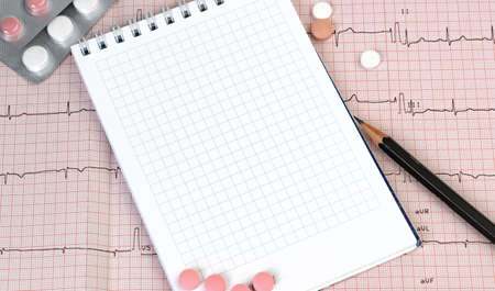 Empty Notebook page on a table with a pills and pencil, medical concept, top viewの写真素材