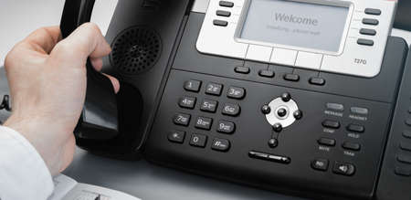 Cropped view businessman or picking or hanging up handset. Office conceptの写真素材