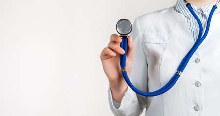 Cropped view of Woman Doctor in uniform standing and holding a stethoscope. Copy space for your textの写真素材