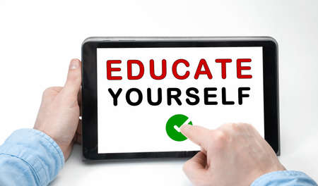 Male hands holding tablet pc with text EDUCATE YOURSELF on white backgroundの写真素材