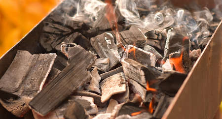 Smoldering charcoal in a bonfire, background texture.の写真素材