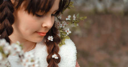 Closeup Pretty child brunette girl 11-12 years in blossom garden, lifestyle