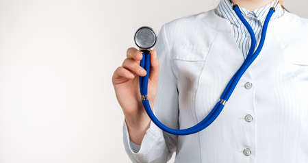 Cropped view of Woman Doctor in uniform standing and holding a stethoscope. Copy space for your textの写真素材
