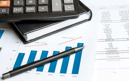 Calculator on financial papers at the table close up. Finance concept