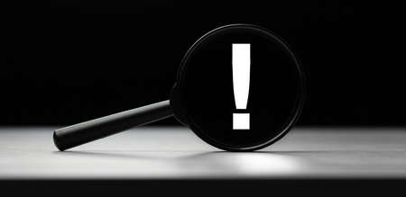 Magnifying glass with text exclamation mark on wooden table. Concept of searchの写真素材