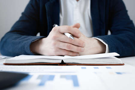Cropped view of businessman works with financial papers at the table. Finance conceptの写真素材
