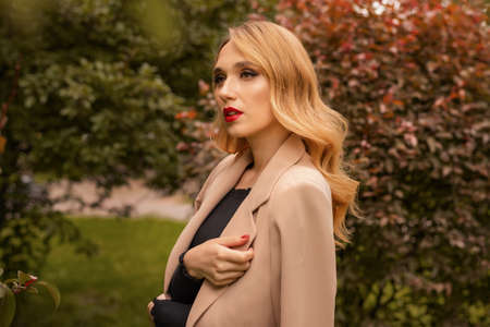 Portrait of young woman with long blonde hair outdoor in autumn park, lifestyle conceptの写真素材