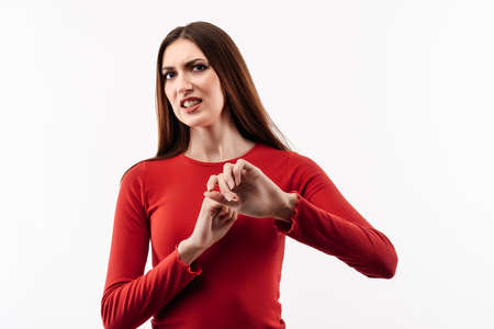 Image of dissatisfied girl with long chestnut hair in casual red sweater doing disgust face because...