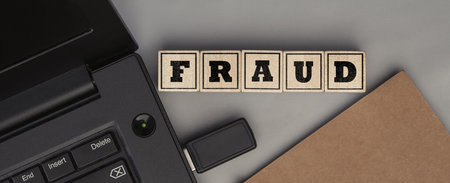 The word FRAUD made from wooden cubes. Conceptual photo. Top viewの写真素材