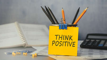 Think positive - concept of text on sticky note. Closeup of a personal agendaの写真素材