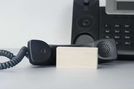 Close up of blank wooden piece blocks on the table near IP phone. Office and communication concept