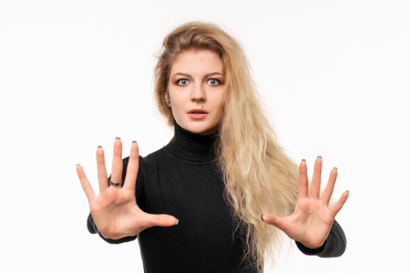 Close up blonde girl feeling stupefied and scared, fearing something frightening, with hands open up front saying stay away. True human reactions, emotions and feelings, isolatedの写真素材
