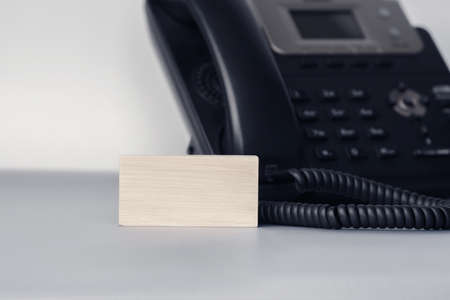 Close up of blank wooden piece blocks on the table near IP phone. Office and communication conceptの写真素材