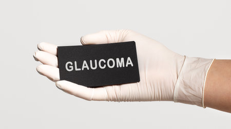Closeup of the hand in a white sterile glove holding a card with word - Glaucoma. Medical conceptの写真素材