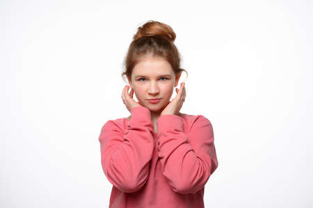 Portrait of a happy little girl in a pink casual sweatshirt. White backgroundの写真素材