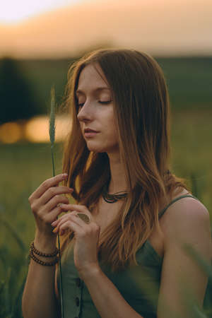 Portrait Gorgeous Young woman with long blond hair on a sunset background. Healthy lifestyle Concept. Image with noise, film grainの写真素材