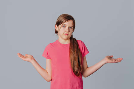 Sorry dont care, nothing to say. Beautiful brunette young girl shrugging with empty open hands...