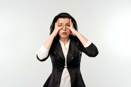 Surprised shocked businesswoman in black formal jacket white shirt, standing over white background. Business conceptの写真素材
