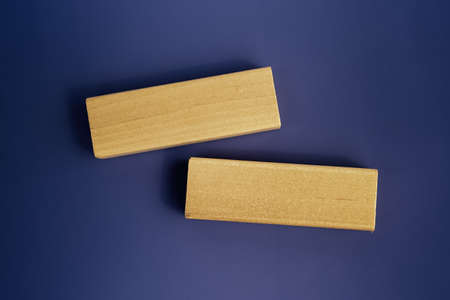 two blank wooden blocks over dark blue background. business strategy template. Copy space, layout,...