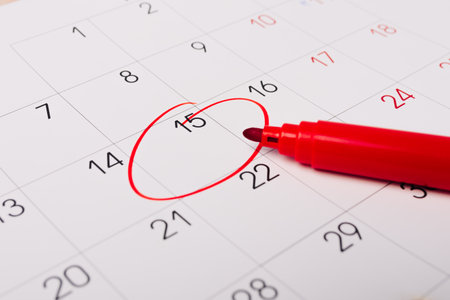 Calendar page with red pen close up. Focus on number 15 in calendar and empty red circle for design in your ideas and work conceptの写真素材