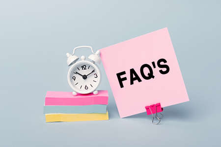 FAQ - frequently asked questions - concept of text on pink sticky note. Close up of a personal...