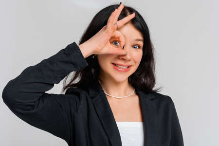 Face portrait of beautiful teen girl smiling, showing okay, ok, zero no problem gesture and...