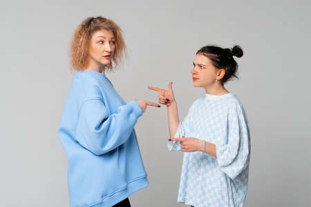 mother daughter conflict. Argument between annoyed teen daughter and upset middle aged mother. Bad, unhealthy, toxic family relationship conceptの写真素材