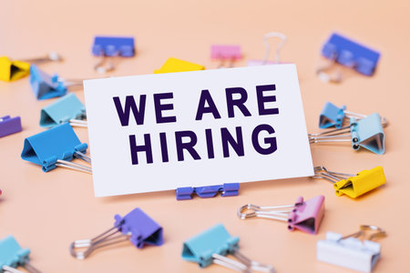 Text - We are hiring, written on paper. Employee vacancy announcement. Business recruiting, Hiring...