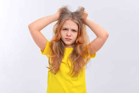Young woman is under huge mental pressure. Portrait of freaked out shocked teen girl pulling out...