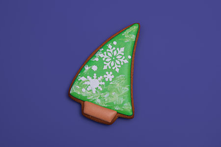 Christmas tree shaped gingerbread cookie on purple background, top view. close-up. Christmas...