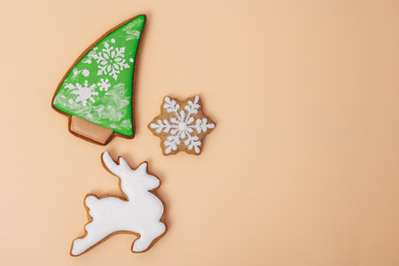 Christmas holiday background with gingerbread cookie of white deer shaped, christmas tree and snowflake on color background, top view, space for text. Happy new year and merry christmas conceptの写真素材