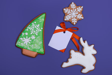 Tasty homemade Christmas cookies and white paper for congratulations text on purple background, top view. close-up. Happy new year and merry christmas conceptの写真素材