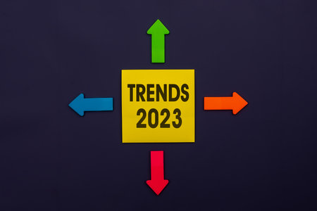 TRENDS 2023 - inscription of a yellow paper note next to an four colorful arrows over a dark blue background. Business management,Inspiration to success ideasの写真素材