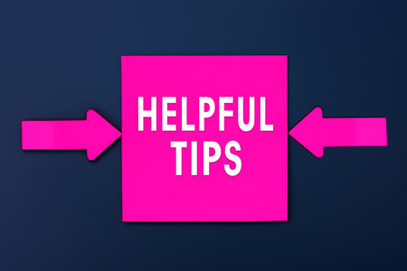 Helpful Tips - inscription of a magenta paper notes and two colorful arrows over a dark blue background. top view. business tips and tricks conceptの写真素材