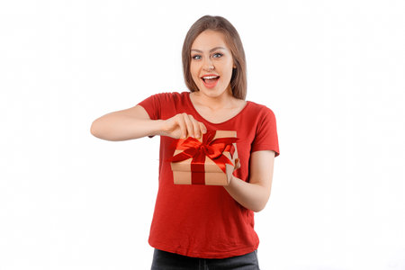Portrait of a happy smiling girl opening a gift box and posing over white background. International Women's Day, New Year, Christmas, Birthday and Valentine's Day concept celebrationの写真素材