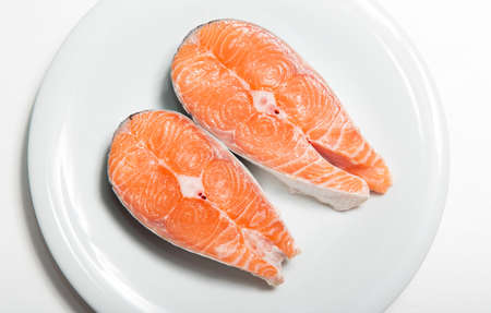 Two steaks of fresh salmon on a white plate. Raw red fish steak. Delicacy. Photos for sale of salmon and trout.の写真素材